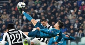 TOPSHOT - Real Madrid's Portuguese forward Cristiano Ronaldo (C) overhead kicks and scores during the UEFA Champions League quarter-final first leg football match between Juventus and Real Madrid at the Allianz Stadium in Turin on April 3, 2018. / AFP PHOTO / Alberto PIZZOLI (Photo credit should read ALBERTO PIZZOLI/AFP/Getty Images)